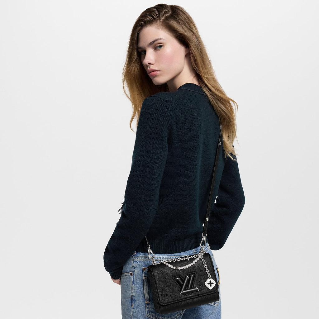 Sac à main Louis Vuitton en cuir noir avec logo LV et chaînes décoratives argentées